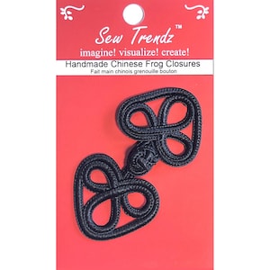 Puede incluir: Cierres de rana chinos negros hechos a mano sobre un fondo rojo. Los cierres están hechos de un material tejido y tienen un diseño en forma de ocho. El embalaje incluye el texto "Sew Trendz" y "Handmade Chinese Frog Closures."