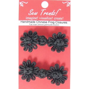 Puede incluir: Dos pares de cierres de botón de rana chinos negros, también conocidos como cierres de botón, sobre un fondo rojo. El embalaje incluye el texto "Sew Trendz! imagine! visualize! create! Handmade Chinese Frog Closures Fait main chinois grenouille bouton."