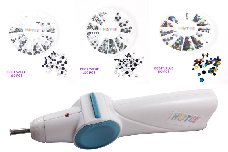 May include: A white hotfix applicator tool with a teal switch and a metal tip, accompanied by three circular white storage wheels containing assorted rhinestones. Each wheel is labeled HOTEE and BEST VALUE 300 PCS, featuring clear, black, and multicolored crystals.