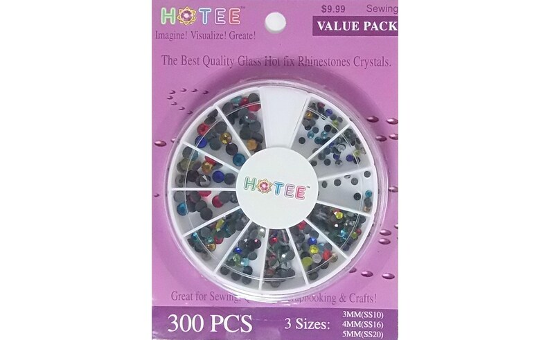 May include: A circular white plastic organizer case filled with 300 multi-colored glass hot fix rhinestones in three sizes: 3mm (SS10), 4mm (SS16), and 5mm (SS20). The packaging is purple with the text HOTEE, Imagine! Visualize! Create!, and Value Pack.