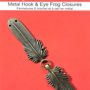 May include: A pair of antique gold metal feather-shaped hook and eye closures.  Sew Trendz imagine! visualize! create! Metal Hook & Eye Frog Closures Fermetures à crochet et à oeil en métal