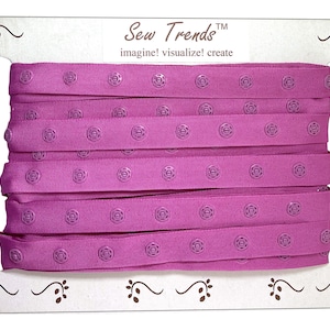 May include: A roll of pink sew-on hook and loop tape with a white label that reads "Sew Trends™ imagine! visualize! create".