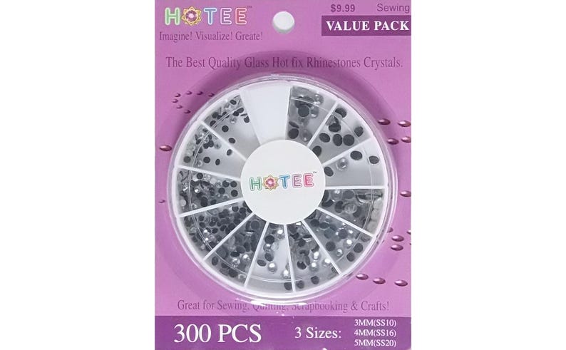 May include: A circular plastic container with twelve compartments filled with clear glass hot fix rhinestones. The packaging is purple with the text HOTEE, 300 PCS, and 3 sizes: 3MM(SS10), 4MM(SS16), 5MM(SS20) printed on the front surface.