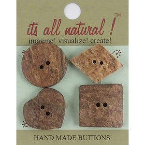 May include: Four brown textured buttons in circular, diamond, heart, and square shapes, each with two centre holes. The buttons are attached to a light green card labelled its all natural! imagine! visualize! create! and HAND MADE BUTTONS.