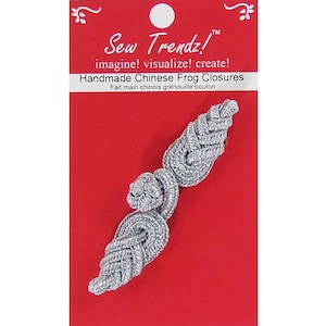 Puede incluir: Cierres de rana chinos hechos a mano de color plateado sobre un fondo rojo. El paquete dice "Sew Trendz!" y "Handmade Chinese Frog Closures". Estos cierres son un elemento decorativo para proyectos de costura.