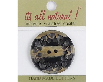 May include: A round, two-hole button with a marbled black and tan pattern, displayed on a card labeled "its all natural! imagine! visualize! create!" and "HAND MADE BUTTONS". The button features a textured, scalloped border design.