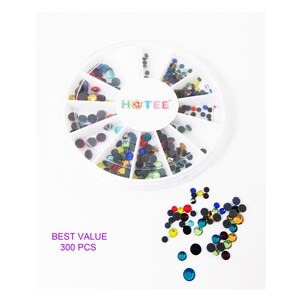 May include: A circular white plastic storage container with twelve divided compartments containing assorted small, round, multi-colored rhinestones. The center of the lid features the text HOTEE. Loose rhinestones are scattered below with text reading BEST VALUE 300 PCS.