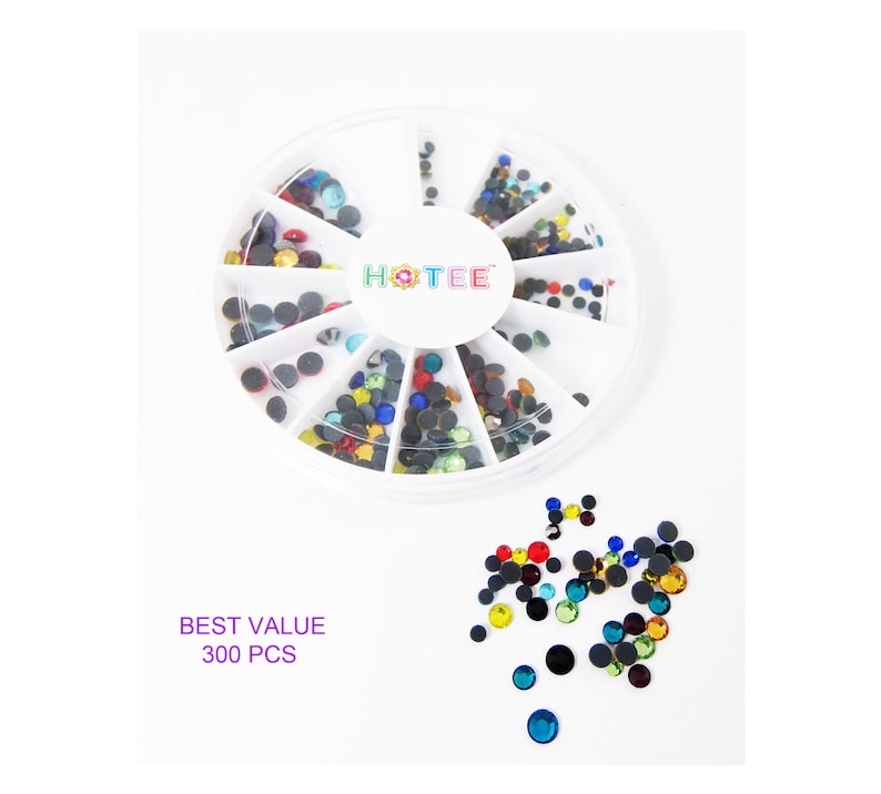 May include: A circular white plastic storage container with twelve divided compartments containing assorted small, round, multi-colored rhinestones. The center of the lid features the text HOTEE. Loose rhinestones are scattered below with text reading BEST VALUE 300 PCS.