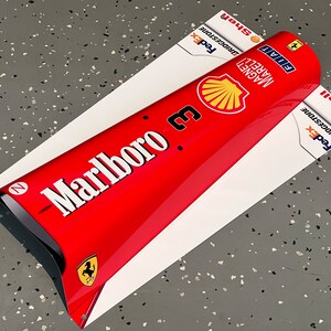May include: A red and white Formula 1 race car nose cone with the Marlboro logo, the number 3, and sponsors like FedEx, Bridgestone, and Shell.