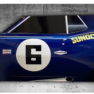 May include: A blue car door panel with the number 6 in a white circle. The panel has the Sunoco logo in yellow, a Champion sticker, and a Goodyear logo. The car door is mounted on a grey concrete wall.
