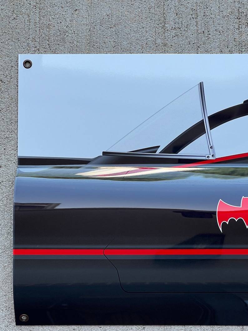 K&ouml;nnte beinhalten: Ein schwarzer und roter Batmobil mit einem klaren Heckfenster. Das Auto hat einen roten Streifen an der Seite und ein Fledermauslogo auf der R&uuml;ckseite.