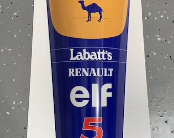 May include: A blue and yellow vintage metal sign with the Camel logo, Labatt's, Renault, Elf, and the number 5. The sign also features the logos for Goodyear, Magneti Marelli, and Canon.