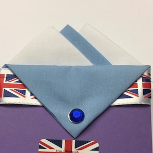 May include: A purple fabric envelope with a blue and white fabric square inside. The envelope has a Union Jack ribbon and a blue rhinestone. The envelope has a label with the text "From: Hipster UK 38 West Street Dunstable Beds LU6 ITA Text only 07803 293693 www.hipsteruk.co.uk"