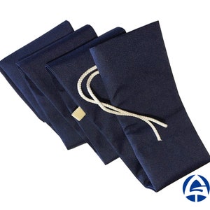 Puede incluir: Un conjunto de tres bolsas rectangulares de tela azul marino con un tejido texturizado. Cada bolsa cuenta con un cierre de cord&oacute;n trenzado blanco y una peque&ntilde;a etiqueta rectangular de color claro unida a la costura lateral.