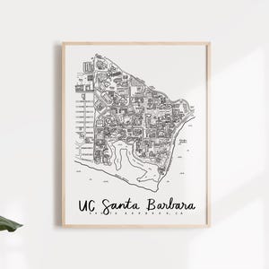 May include: A framed black and white map of UC Santa Barbara, with the text "UC Santa Barbara" in a handwritten font. The map details the campus layout, including buildings, roads, and the coastline.