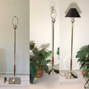 May include: Three floor lamps with brass and wood bases. The lamps have different shades, including a black drum shade and a white globe shade.