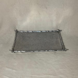 May include: A silver tray with a woven bamboo design. The tray is rectangular and has a raised edge.