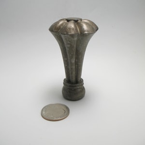 May include: A silver metal finial with a fluted design. The finial is about the size of a US quarter.