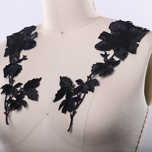 May include: Black floral lace applique with a delicate design of roses and leaves. This applique is perfect for adding a touch of elegance to any garment or craft project.