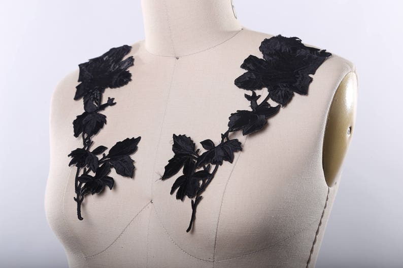 May include: Black floral lace applique with a delicate design of roses and leaves. This applique is perfect for adding a touch of elegance to any garment or craft project.