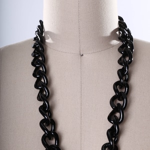 May include: A thick black plastic chain necklace. The chain is made of large, chunky links.