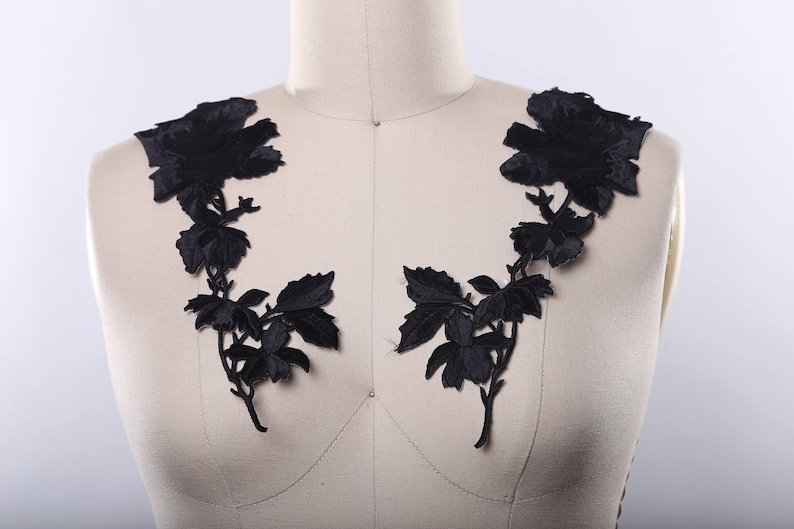 May include: Black floral lace applique with a delicate design of leaves and flowers. This applique is perfect for adding a touch of elegance to any garment or project.