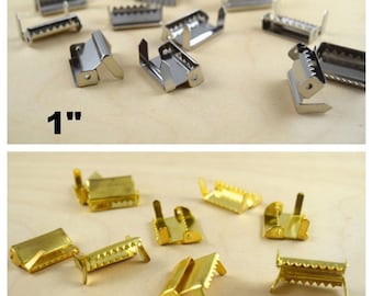 May include: Two sets of metal slider buckles, one set is silver and the other is gold. The silver set is labelled "1" with a quotation mark. The buckles are approximately 2.5 cm in size.