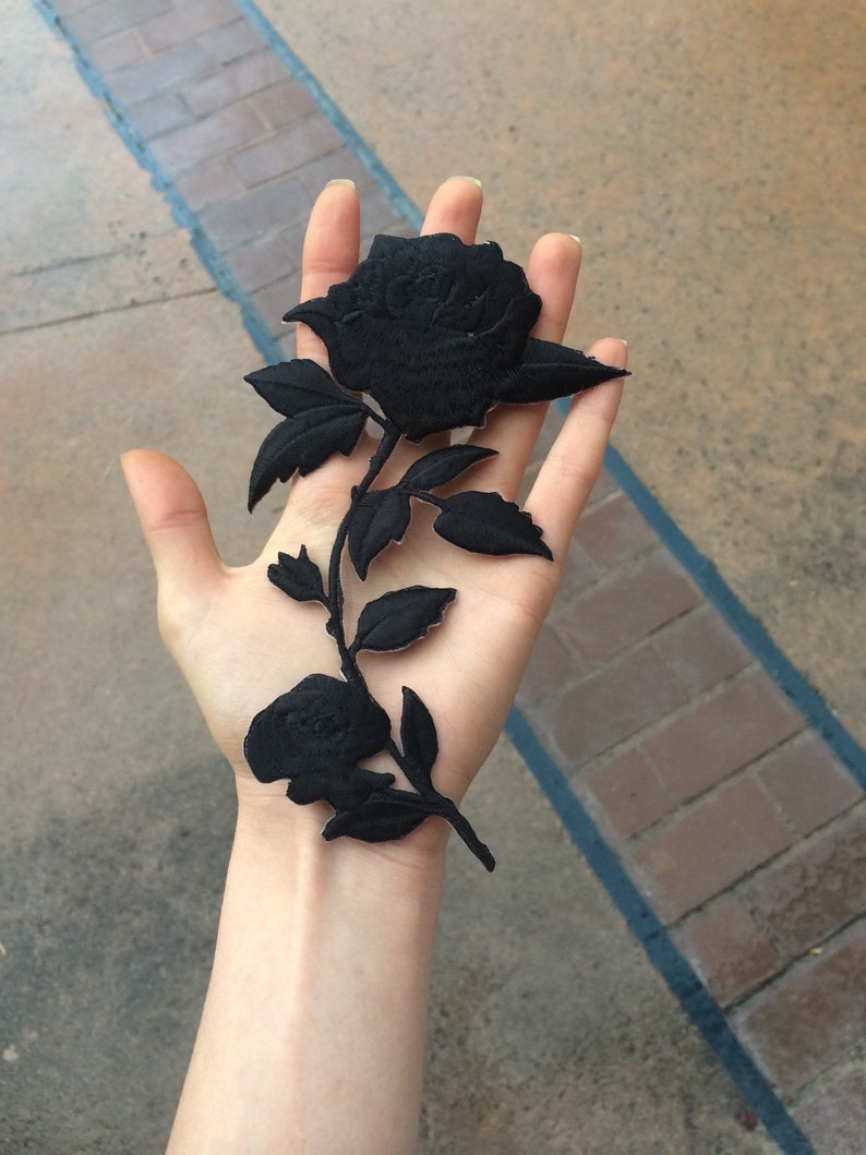 May include: Black fabric rose patch with a stem and leaves. The rose is embroidered with a detailed design.