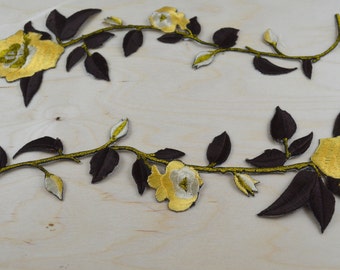 May include: Two embroidered floral appliques with brown stems and leaves and yellow and white flowers.