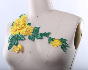 May include: A yellow and green floral applique with a cluster of yellow roses and green leaves.