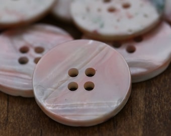 May include: Four-hole pink and white shell buttons with a pearlescent finish.