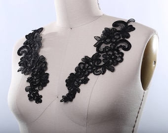 May include: Black lace trim with a floral design. The trim is shown on a dress form.