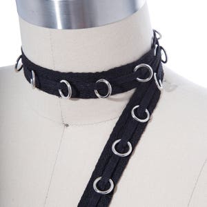 Passacavo nero con anelli in argento/Anelli pendenti scorrevoli attraverso il nastro di cotone/Rifinitura da 0,75"/Rifinitura con occhielli neri/Perfetto per corsetteria