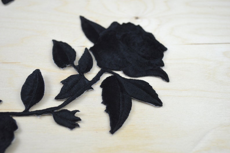May include: Black velvet rose applique with leaves. This embroidered patch is perfect for adding a touch of elegance to clothing, bags, or home decor projects.