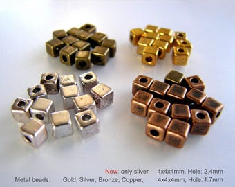 Könnte beinhalten: Sortiment an Metall-Würfelperlen in Gold, Silber, Bronze und Kupfer. Die Perlen sind 4 mm x 4 mm x 4 mm groß und haben eine Lochgröße von 2,4 mm oder 1,7 mm.