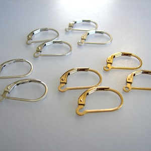 May include: A set of earring findings, including silver and gold-toned options. The findings are made of metal and have a hook closure.