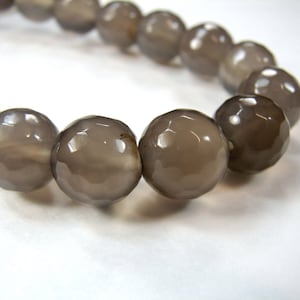 May include: A grey gemstone bracelet with faceted beads. The bracelet is made of natural stone and has a simple, elegant design.