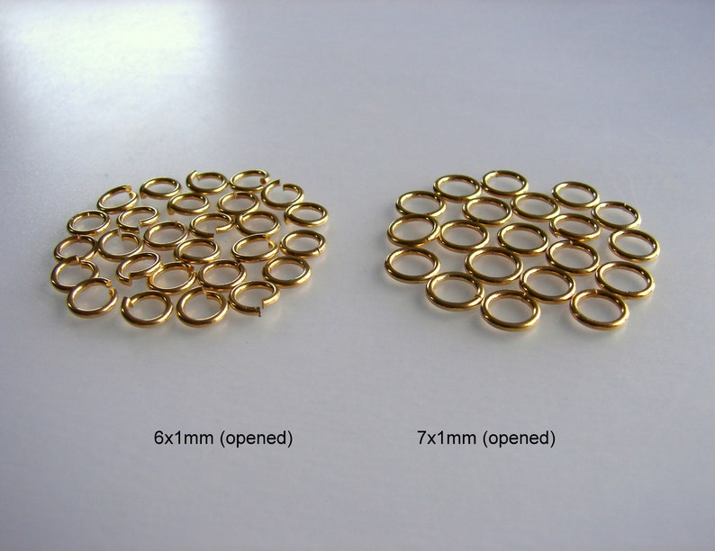 May include: Two groups of gold jump rings, one group of 6 mm rings and one group of 7 mm rings. Both groups are arranged in a circular pattern and are open.