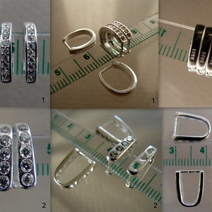 May include: Four silver-toned pendant bails with clear cubic zirconia stones. The bails are approximately 1 inch long and have a rounded, open design. The stones are set in a row along the bail. The bails are shown against a white background with a ruler for scale.