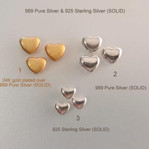 May include: Three groups of small heart-shaped charms labeled 1, 2, and 3. Group 1 features 24K gold plated over 999 pure silver. Group 2 features 999 pure silver. Group 3 features 925 sterling silver. Text reads 999 Pure Silver & 925 Sterling Silver (SOLID).