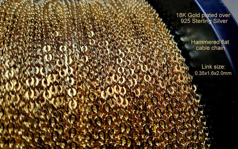 K&ouml;nnte beinhalten: Nahaufnahme einer goldplattierten, geh&auml;mmerten, flachen Kabelkette. Die Kette ist 18K goldplattiert &uuml;ber 925 Sterling Silber. Die Gliedergr&ouml;&szlig;e betr&auml;gt 0,35x1,6x2,0 mm. Das Bild zeigt die Textur und das Design.