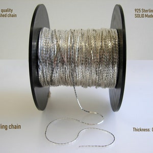 May include: A spool of silver beading chain, 925 sterling silver, made in Italy. The chain is 0.6 mm thick and is labeled as high quality unfinished chain.