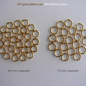 May include: Two groups of gold-plated jump rings, 925 sterling silver. The group on the left is 6 mm in diameter and the group on the right is 7 mm in diameter. Both groups are open.