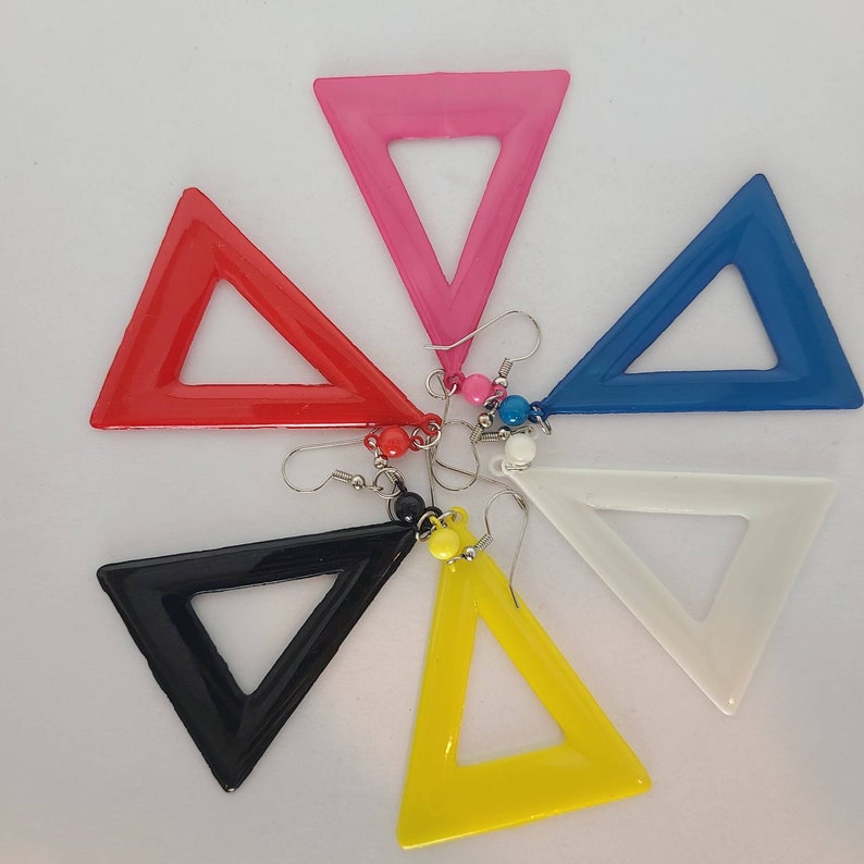 May include: Six pairs of triangle-shaped earrings in various colors, including pink, red, blue, black, white, and yellow. Each earring has a small bead at the top.