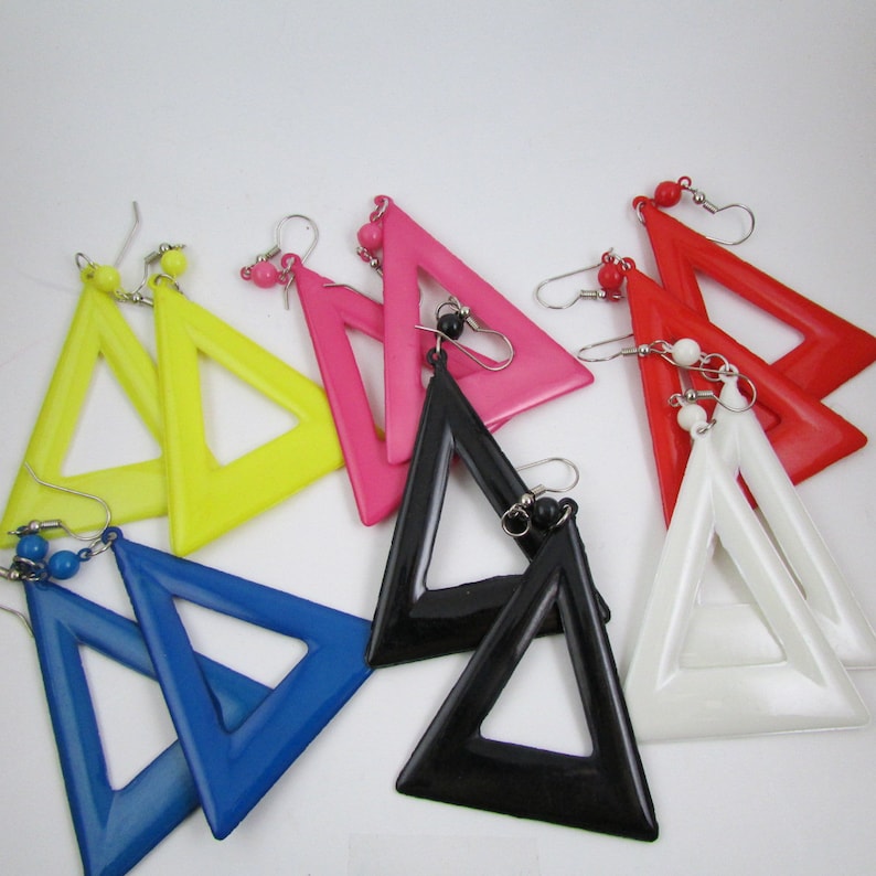 May include: A set of eight triangle-shaped earrings in various colors, including yellow, pink, red, white, blue, and black. The earrings are made of plastic and have a geometric design.
