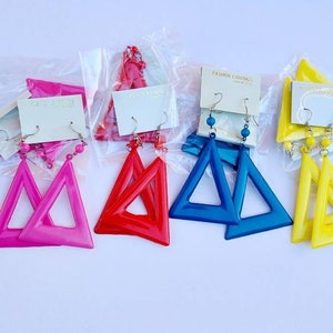 May include: Assortment of triangle-shaped earrings in various colors, including white, pink, red, blue, yellow, and black. The earrings are packaged in clear plastic bags with a small card that says "Fashion Earrings".