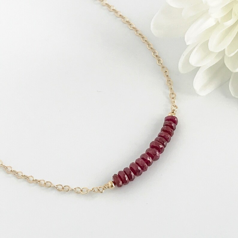 A row of red ruby gemstones on a chain.  The row is approximately 1 inch long and the chain is available in 14k gold filled or sterling silver.