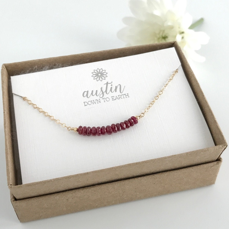 A row of rubies on a gold filled chain in a gift box.  A perfect July birthday gift.