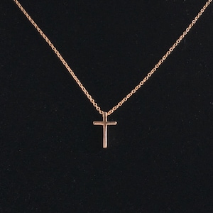 A small .5 inch rose gold cross on a dainty rose gold chain.