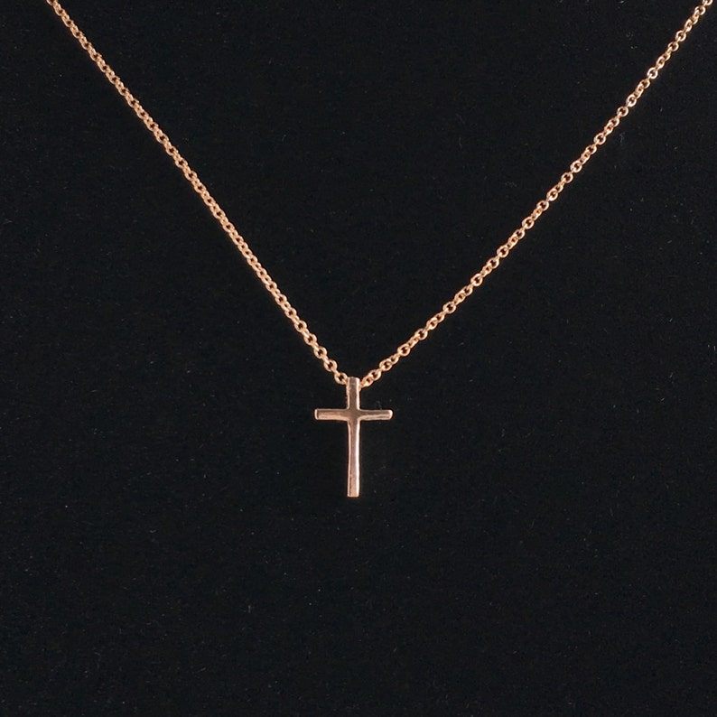 A small .5 inch rose gold cross on a dainty rose gold chain.